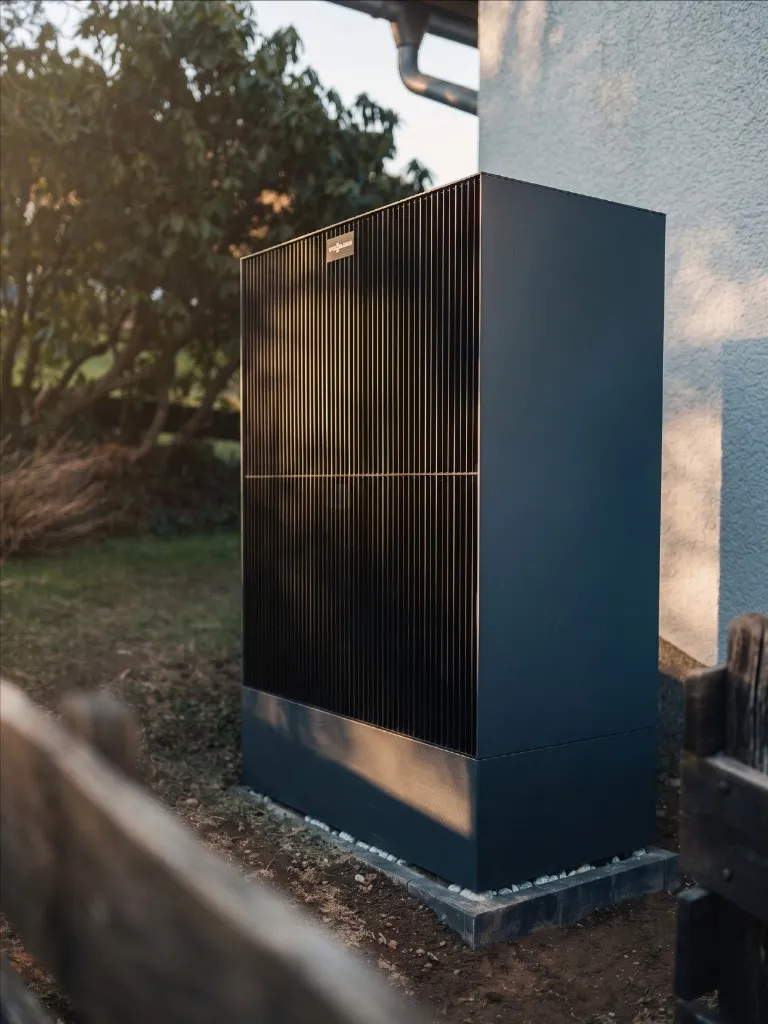Moderne Viessmann Wärmepumpe im Gartenbereich eines Einfamilienhauses.