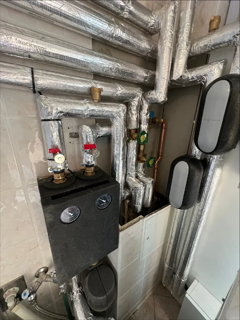 Heiztechnik im Keller mit Speicher und sauber verlegter Rohrführung.